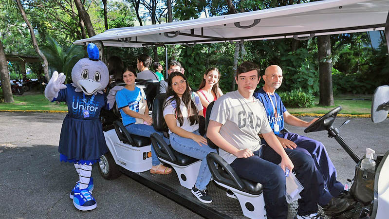 alunos em carrinho elétrico no campus da unifor