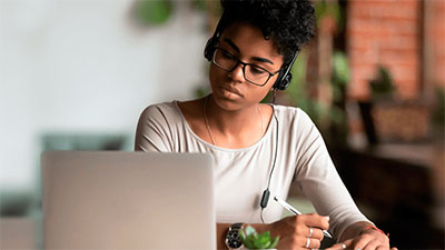jovem usando o computador com fone de ouvido