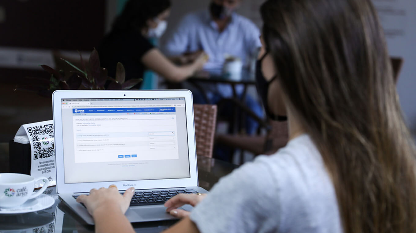 Jovem usa notebook onde a tela exibe a ferramenta Unifor Online.