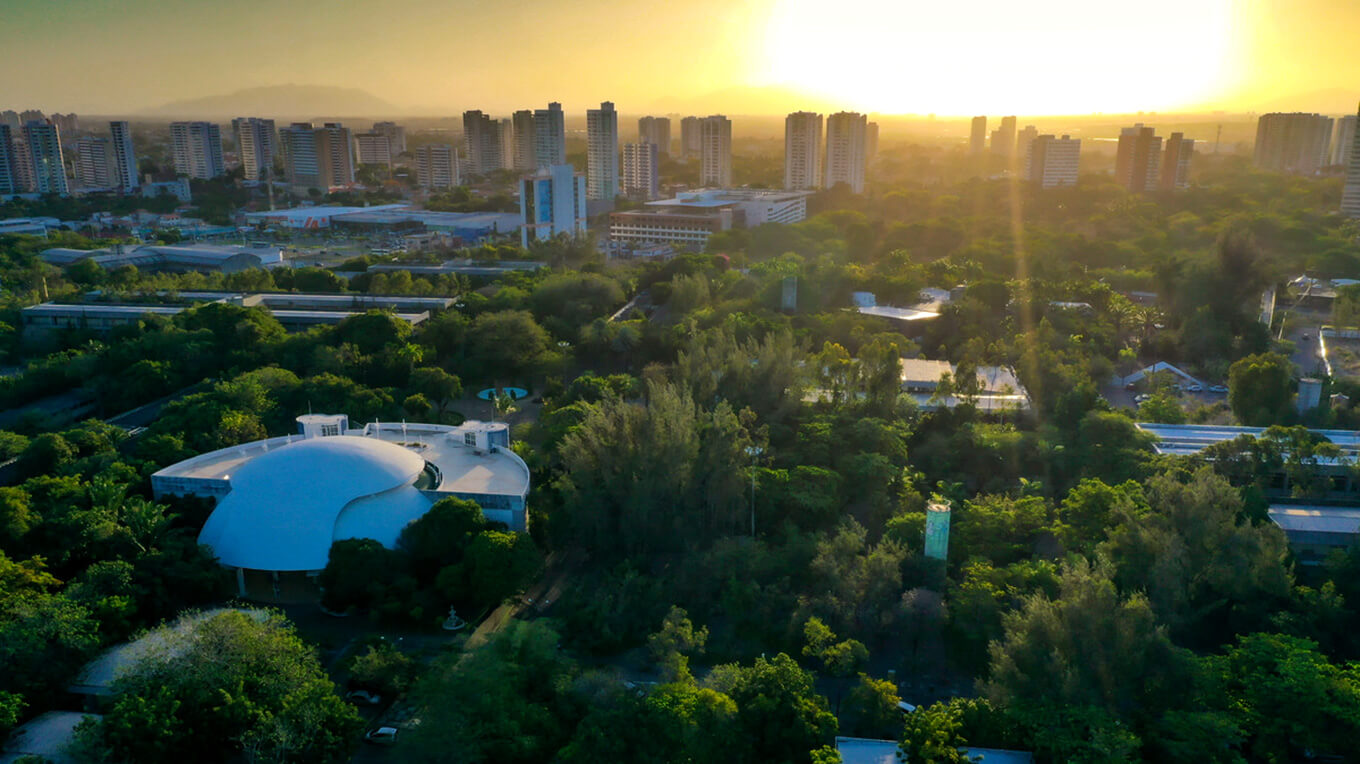 Campus da Unifor em foto aérea com muitas árvores e o Centro de Convivência