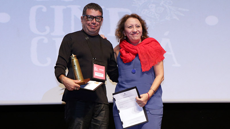 Cineasta Émerson Maranhão recebe prêmio das mãos da coordenadora do curso de Cinema e Audiovisual da Unifor, professora Bete Jaguaribe (Foto: Rogério Resende)
