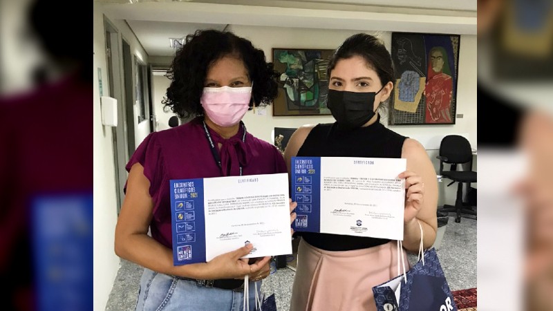 A estudante Lídia Baima (à direita) recebe seu certificado de 1º lugar junto à sua professora orientadora, Luciana França. (Foto: Acervo pessoal)