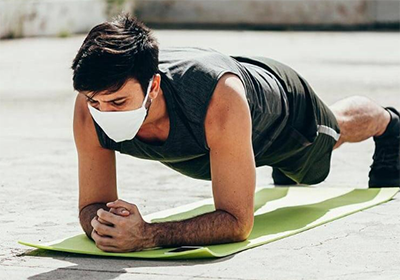 Jovem realizando abdominal do tipo prancha