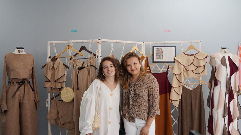 As alunas Ana Beatriz Ribeiro e Bárbara Wirtzbiki com seus trabalhos na Imagem Brasil Galeria. Foto: Divulgação.