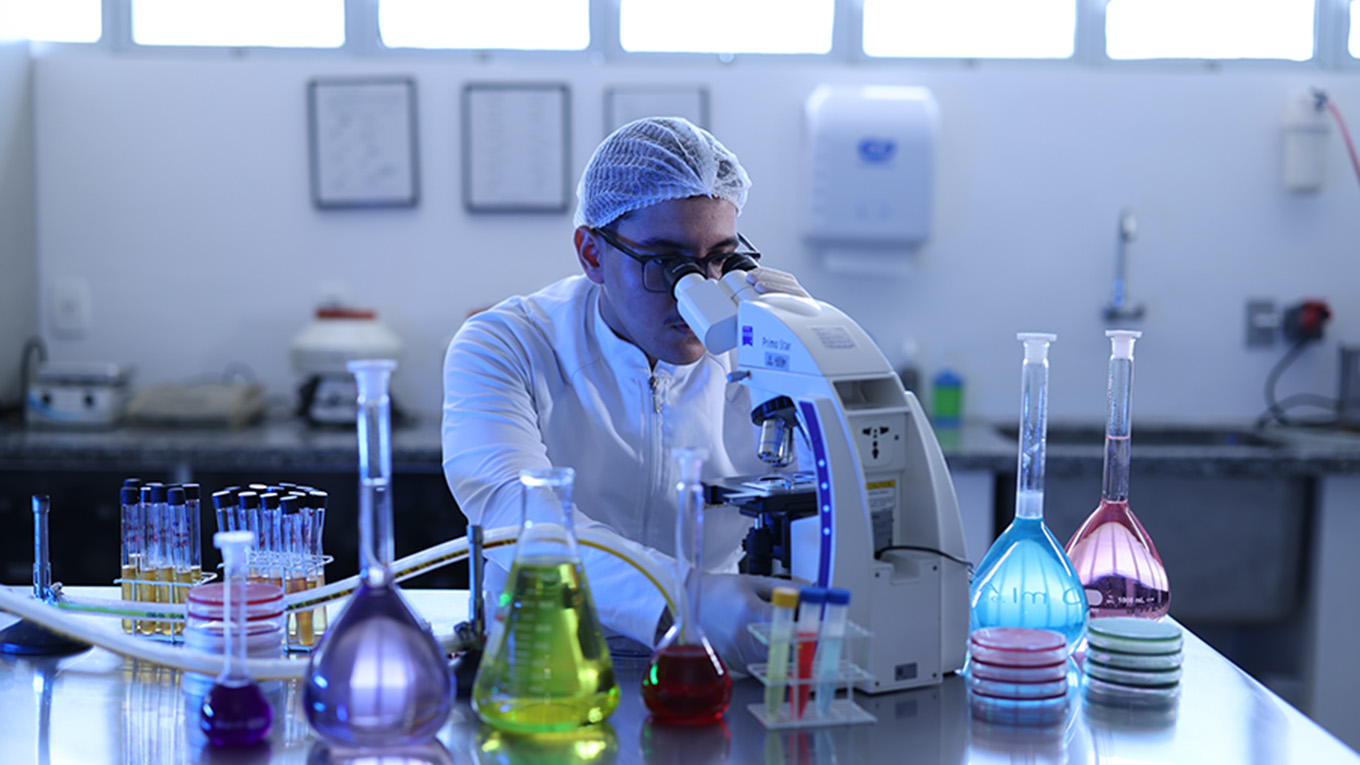 Jovens cientistas manipulam recipientes