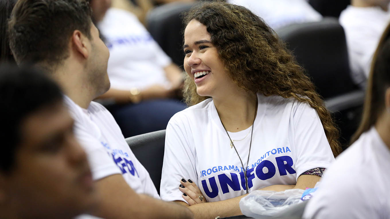 Alunos com a camisa do Programa de Monitoria reunidos no Teatro Celina Queiroz para palestra