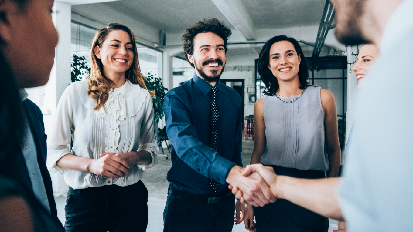 pessoas sorrindo no escritório em aperto de mãos