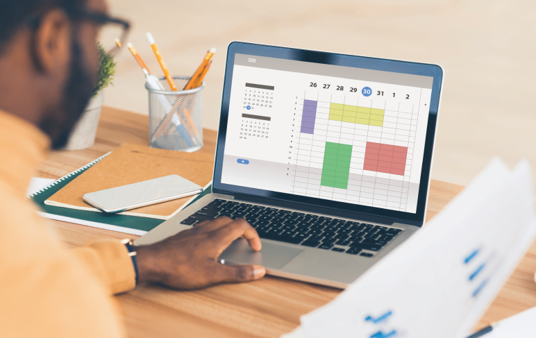 Empresário afro-americano usando calendário online e planejando sua agenda no local de trabalho.