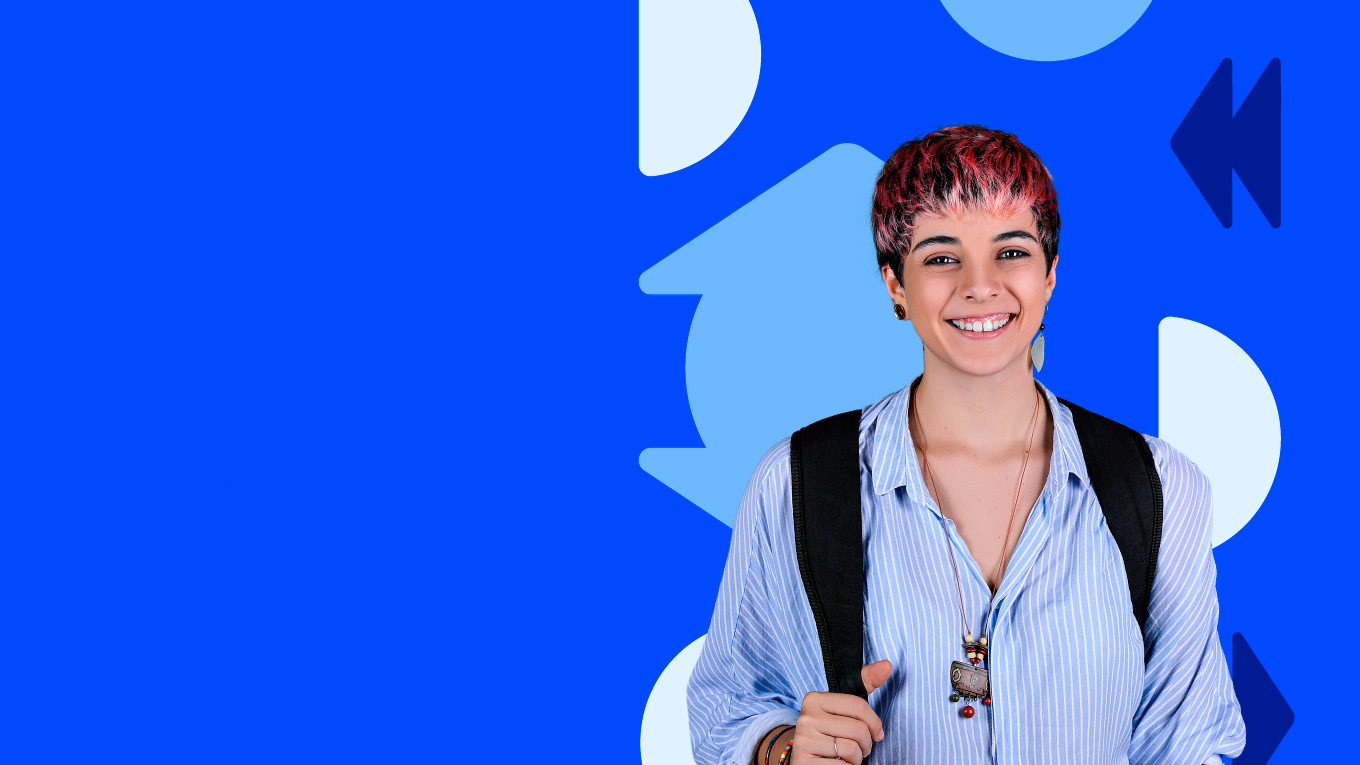 Estudante de cabelo curso e em tons de rosa sorri. Ela usa camisa azul com listras brancas e segura uma mochila.