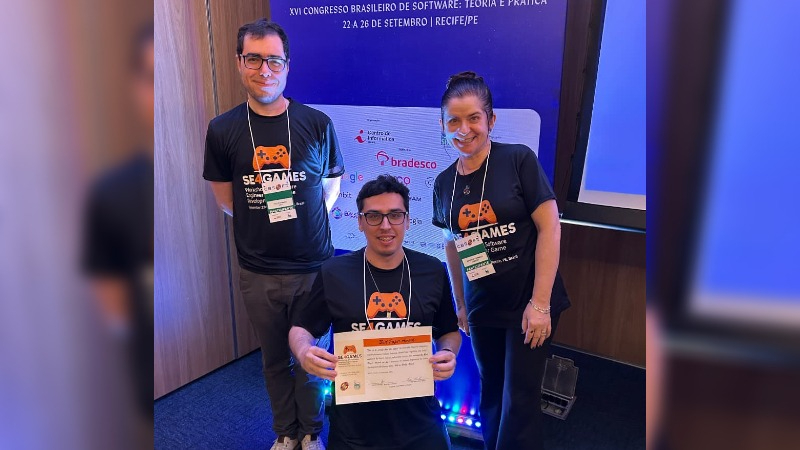 O aluno Raul Costa Feitosa, ladeado pelos professores Troy Kohwalter (CBSoft) e Andréia Formico (GIRA LAB). (Foto: Ares Soares)