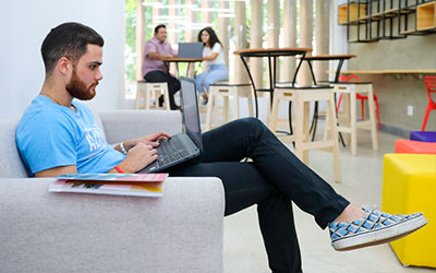 Estudante manuseia laptop no Cafetech