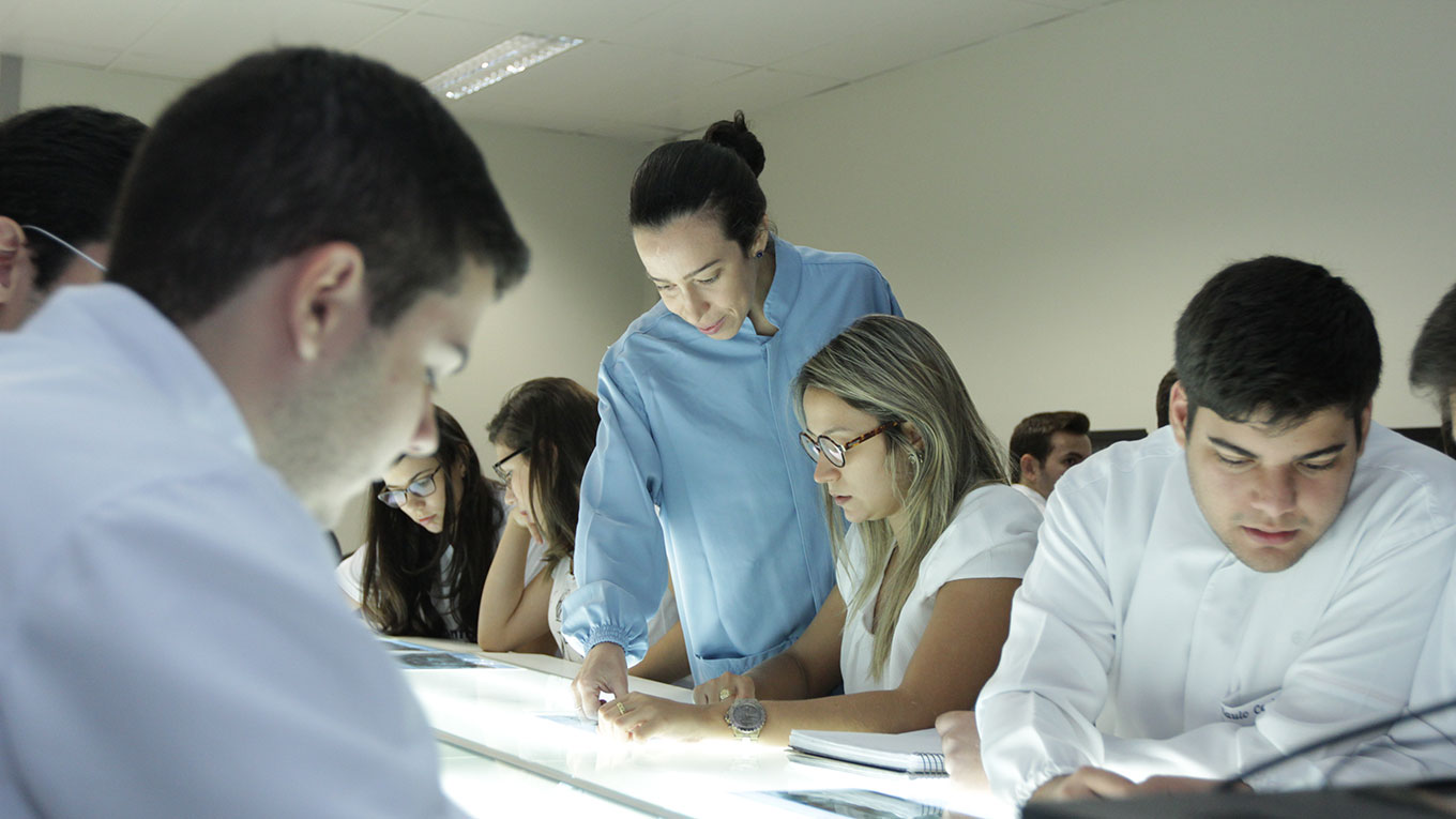 Professora auxilia estudante com exame de radiografia