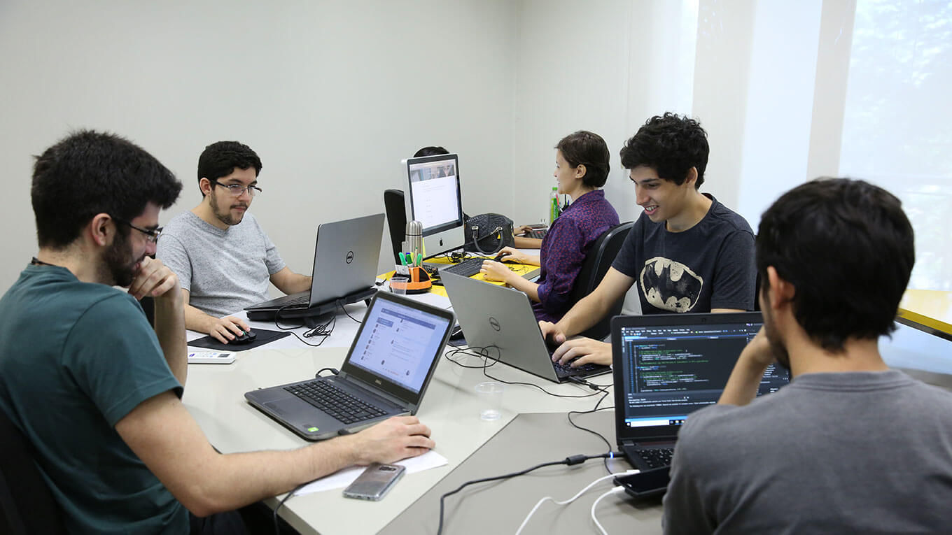 Estudantes sentados com seus respectivos notebooks em sala do LAPIN