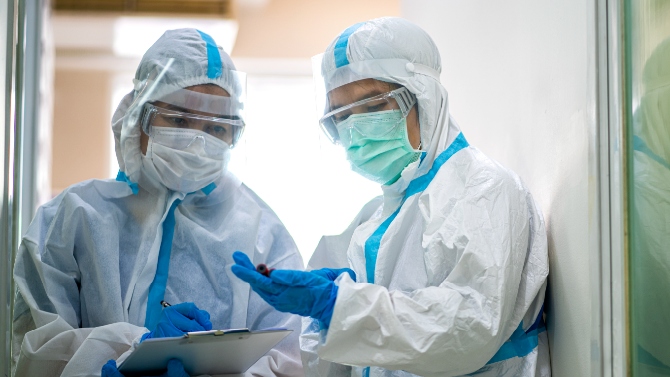 Pessoas protegidas com roupa especial com amostra de sangue